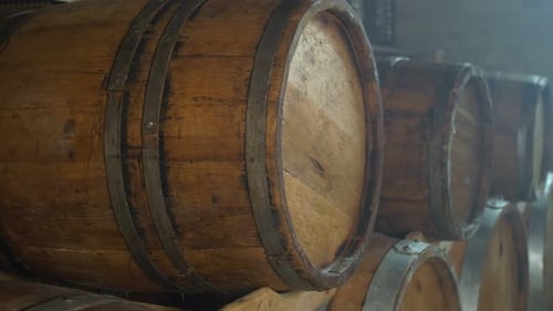 Holzfässer liegen in Reihen im Weinkeller: Weinherstellung, Geschäftsstrategie und Traditionstreue