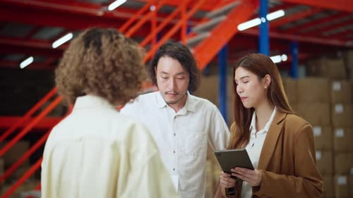 Three warehouse employees having a discussion