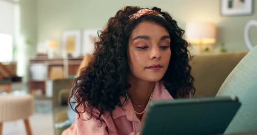 Woman Lies on Couch Using Tablet at Home