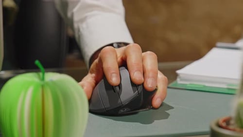 Close up of a man's hand scrolling with a wireless computer mouse