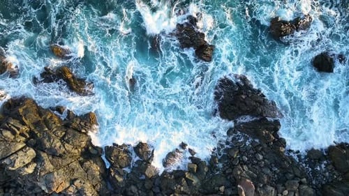 Waves crashing against rocky coastline in a serene ocean setting