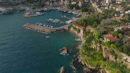 Blick aus der Vogelperspektive auf die Meeresküste im Urlaubsziel zur Goldenen Stunde Tilt Up enthüllt die Gebäude des Yachthafens