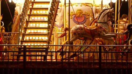 Carousel roundabout or merry-go-round with colourful horses and retro vintage wooden seat