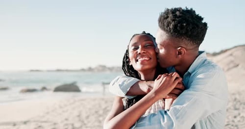 Couple, kiss and embrace on sand at beach for romance, affection and bonding on honeymoon vacation