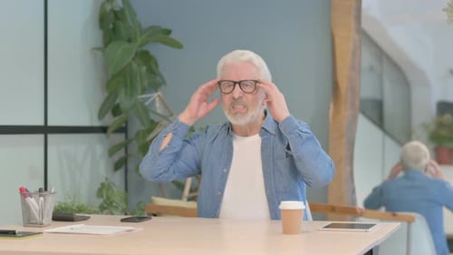 Senior Man Rubbing Temples Due to Discomfort