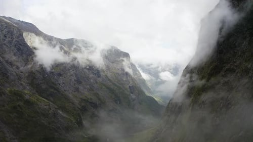 Estrada sinuosa passando por montanhas, neblina e nuvens em Milford Sound, Nova Zelândia, no sul I