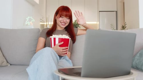 Young Woman Relaxes with Popcorn Watches Funny Trailer on Laptop Laughs Smiles Enjoys Comedy Preview