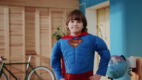 Confident Boy in Superhero Costume Poses in Room
