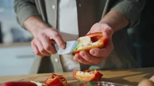 Man Prepares Red Pepper for Salad Indoors
