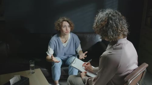 Woman Talks to Healthcare Provider in Somber Office