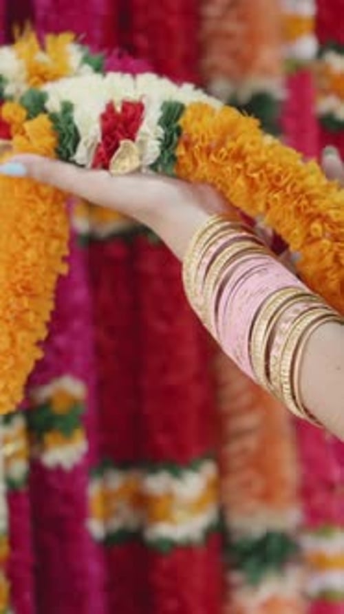 Arm Holding Colorful Floral Garlands with Bangles