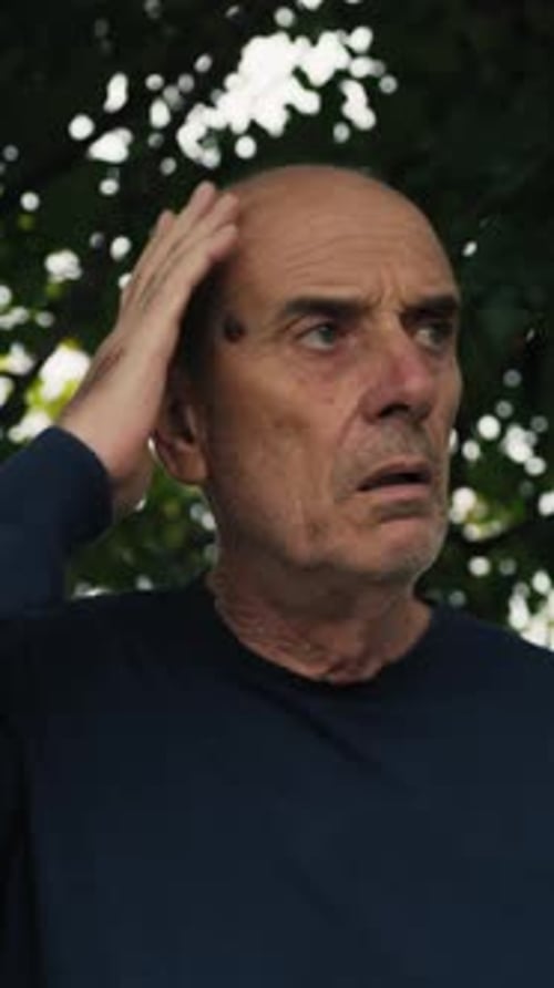 Concerned Older Man Looks Up in Daylight