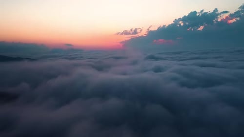 Flying over the clouds with the late sun. Sunrise or sunset colorful sky background.