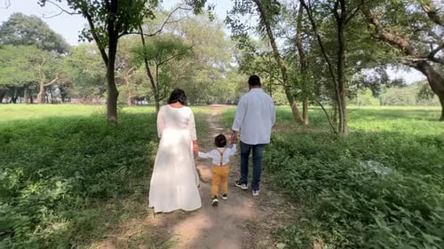 POV shot of a family consisting of father mother and son walking in a forest.