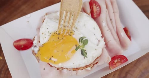 Fork Touches Runny Egg with Toast and Ham
