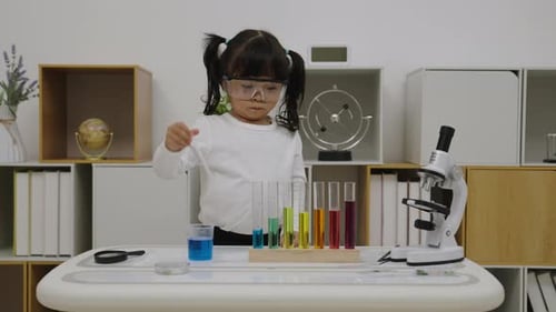 Enthusiastic Girl Scientist Mixes Colorful Liquids at Lab Table