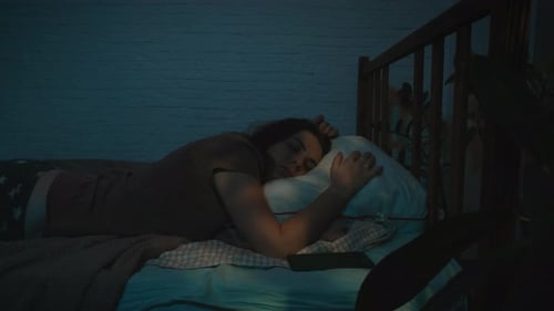 Woman Using Cell Phone Lying in Bed at Night