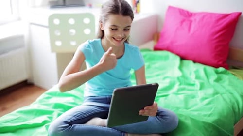 Teenage Girl Smiling and Using a Tablet at Home