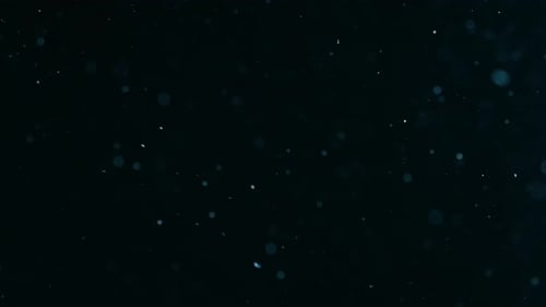 Blaue Schneeteilchen schweben auf schwarzem Hintergrund