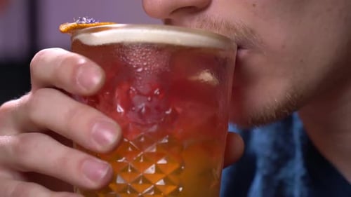 Junger Mann mit Borsten nimmt einen Schluck Bier, Nahaufnahme