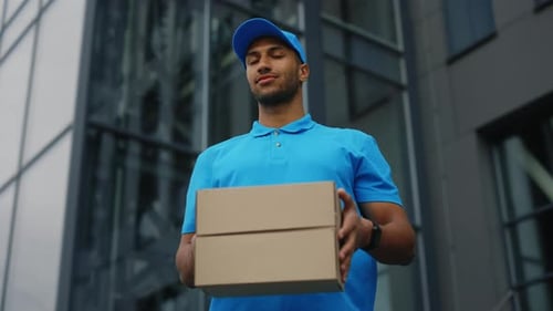 Portrait African American Postman Holding the Paper Boxes Looking at Camera Male Delivery Wearing