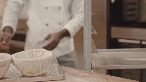 Baker Placing Dough Baskets on Cooling Rack