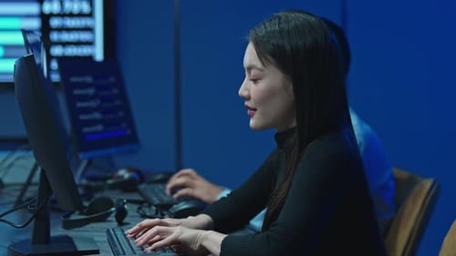 Programadora escribiendo en el teclado durante el turno de noche