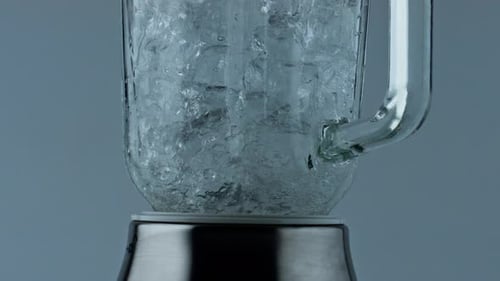 Primer plano de una batidora de cócteles moliendo hielo. Equipo de camarero para triturar cubos congelados en contenedores