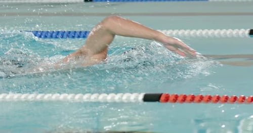 Nadar estilo libre en la piscina, entrenamiento de atletas para la competencia, uso de gorro de natación