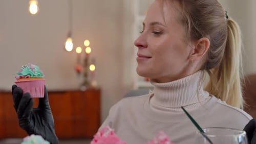 Woman Decorating Cupcakes with Colorful Frosting and Sprinkles