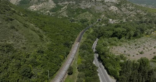 Long Train Carriage Traveling On The Foothill To Mountain Tunnel In Mtskheta, Georgia. - aerial