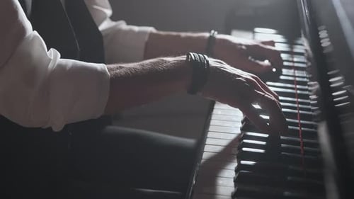 Pianist Playing on the Black Grand Piano on Concert Stage Under Spotlight Close Up Shot of Hands on