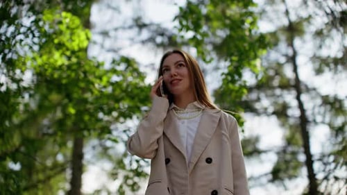 Woman Talking on Phone in Sunny Park