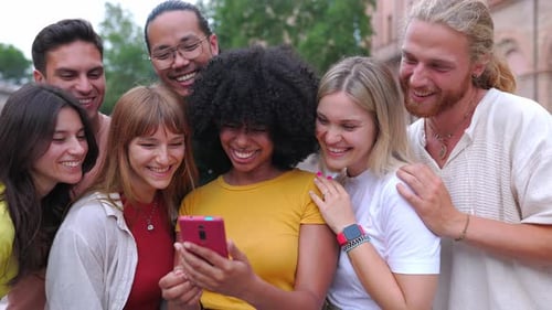 группа людей смеется над телефоном