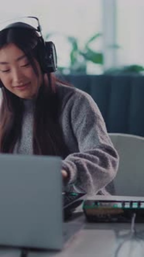 Young Woman Working with Laptop and Mixing Board