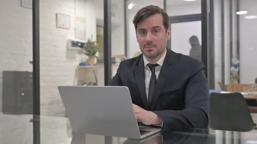 Man in Suit Working on Laptop in Office