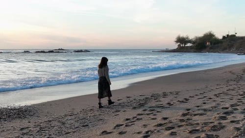 A Beautiful Girl Walks on the Beach of the Mediterranean Sea and Enjoys a Beautiful Sunset