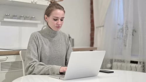 Woman Working on Laptop in Bright Kitchen