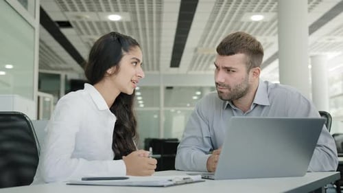 Two Colleagues Man and Woman Business People Talk in Office Discussing Project Looking at Laptop