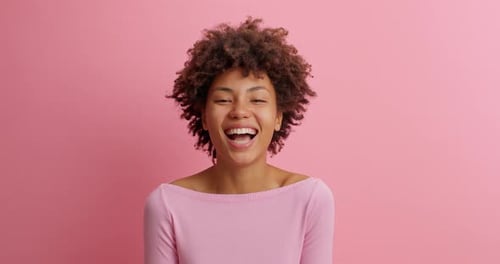 African american woman joyfully laughing loudly at ridiculous anecdote in studio