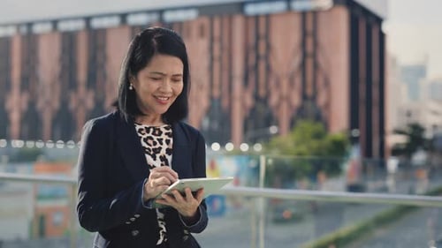 Older Charming Woman Writing Down Data with Digital Pen on Tablet While Standing Outside