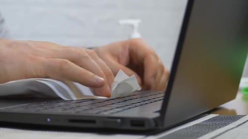 Unrecognizable Man Cleaning Laptop Keyboard Using Wet Wipe