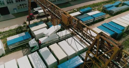 Ladewagen in einem Industrielager mit Kranbalken-Luftaufnahme