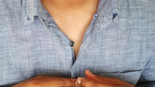 Man Buttoning His Shirt Close Up
