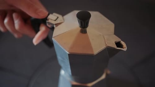 Primer plano de una olla de moka plateada en una estufa de cocina retro. Preparar un café sabroso y cremoso.