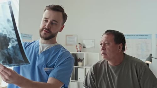 Professional Radiologist Explaining X-ray Image of Spine
