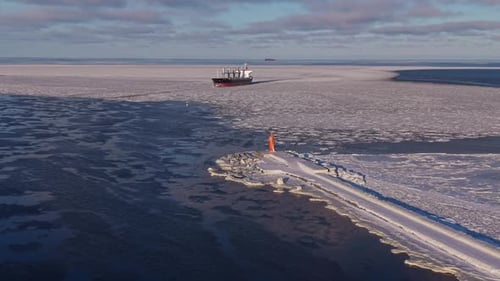 Closeup of Ship Approaching Ice Flying Camera Captures Freighter Approaching Icy Barrier in Water