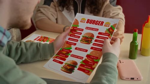 Group of Young People Reading Menu at Fast Food Restaurant