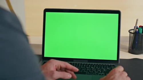 Man Typing on Laptop with Green Screen