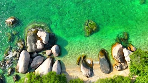 Stunning sandy beach with rock, clean sea water and green forest. 4K.